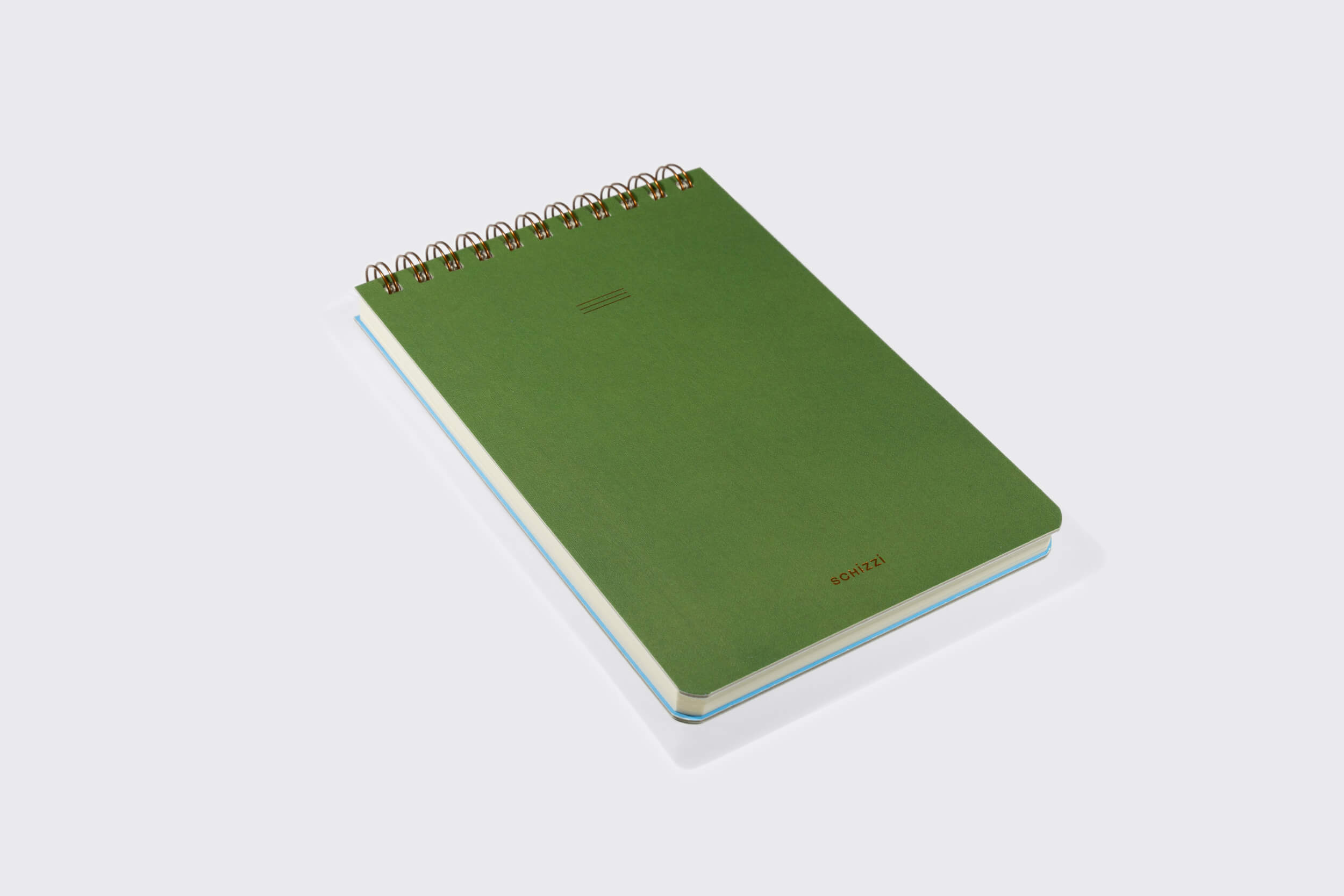 Um Caderno Reporter fechado: Oliva da Schizzibooks repousa sobre uma superfície plana. O caderno verde encadernado em espiral apresenta texto mínimo em relevo dourado no canto inferior direito e páginas macias de papel pólen ligeiramente visíveis ao longo da borda direita, com uma encadernação de bronze wire-o.