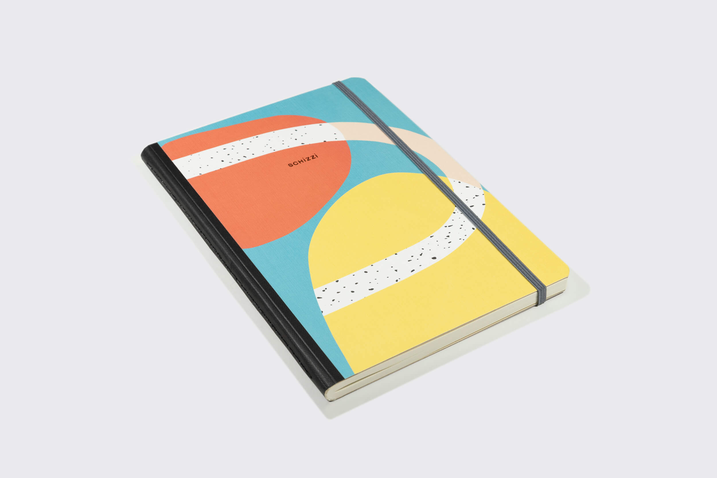 O Sketchbook XLarge: Caminho da Schizzibooks apresenta uma capa geométrica vibrante em azul, laranja, amarelo e branco com "NOTES" em preto forte. Um elástico prende este papel livre de ácidos caderno de esboço descansando sobre uma superfície cinza claro.