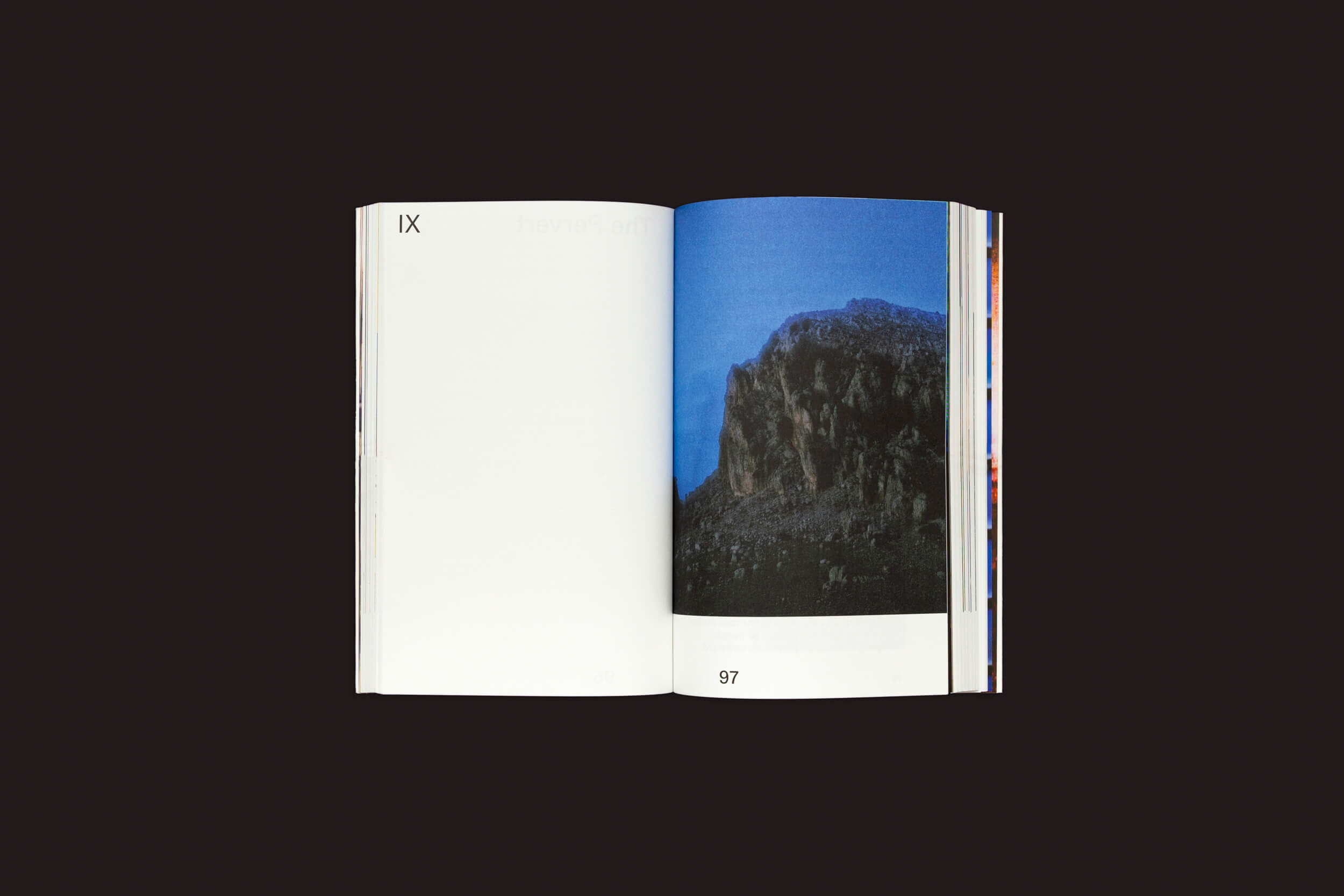 Um livro aberto sobre um fundo escuro mostra as páginas IX e 97. A página da esquerda está em branco, enquanto a da direita apresenta um penhasco rochoso sob um céu azul profundo, ecoando a narrativa de Valeria Cherchi em Some of you Killed Luisa, de The Eriskay Connection.