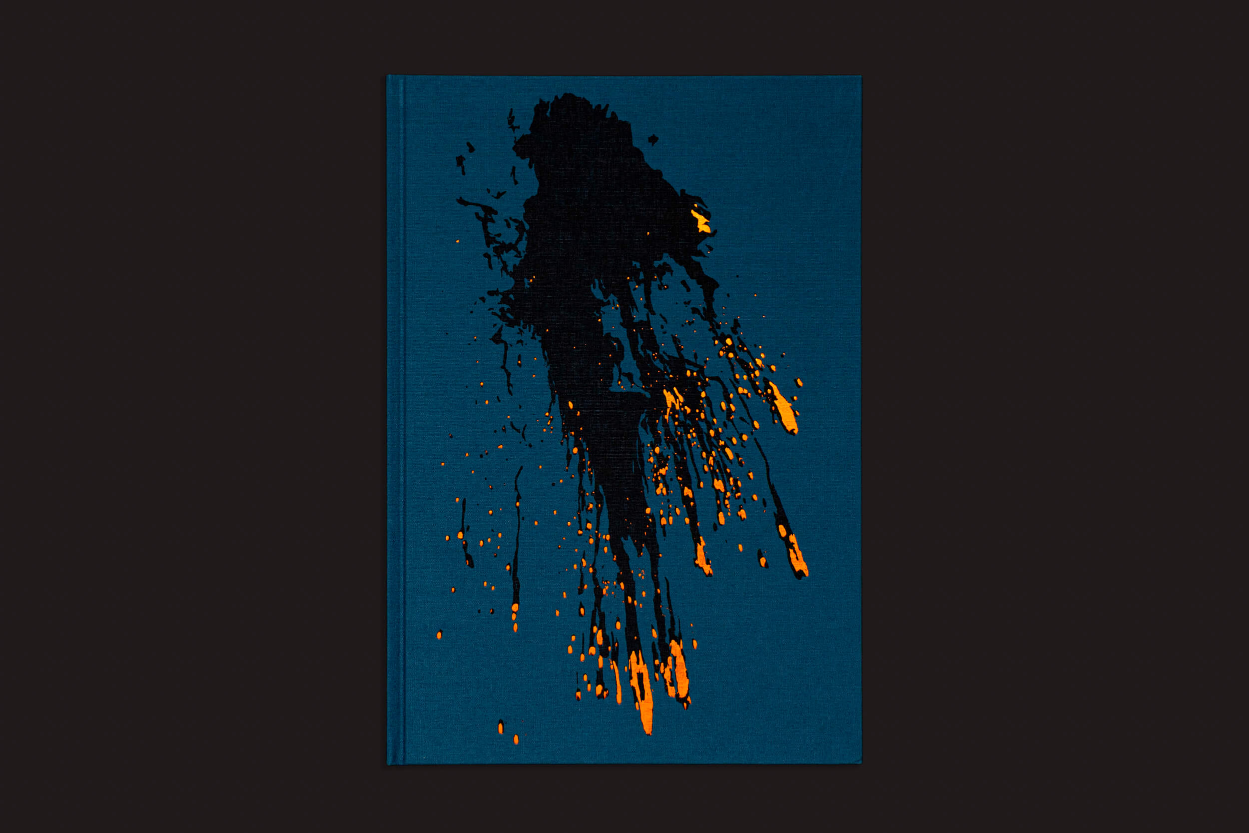 A capa azul de "Kevin Cooley: The Wizard of Awe", da The Eriskay Connection, apresenta respingos de tinta preta abstrata com detalhes em amarelo-alaranjado, evocando mistério e lembrando explosões pirotécnicas. O design arrojado cativa os leitores com seu contraste marcante contra o fundo escuro.