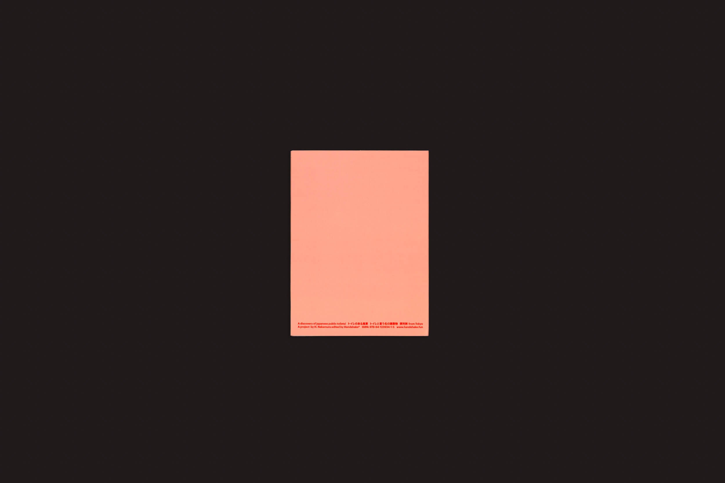 Um pequeno retângulo rosa centralizado em um fundo preto apresenta a elegância minimalista de Hidefumi Nakamura: Toilets a Go Go! de Handshake. Perto da parte inferior, um delicado texto vermelho sussurra suavemente, adicionando um toque enigmático.