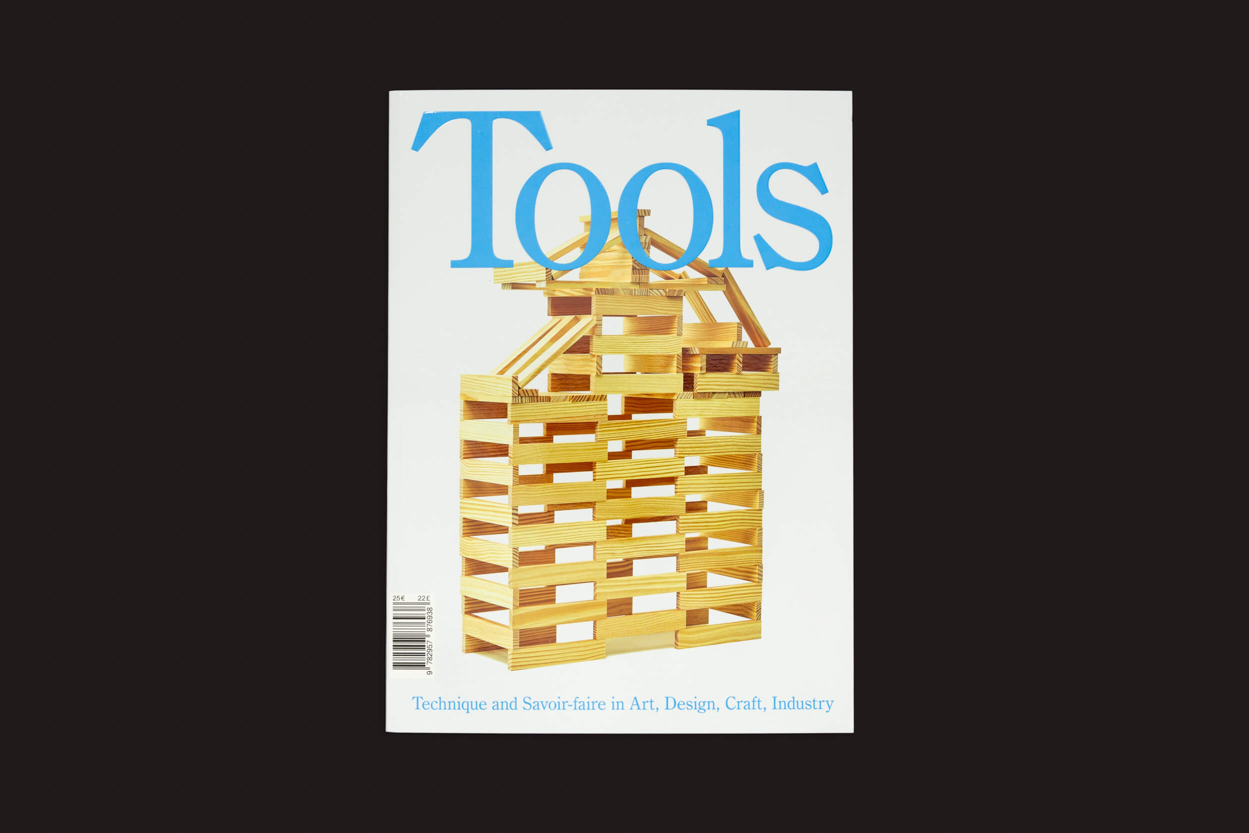 A capa da revista Tools #04 – To Cut mostra uma estrutura de madeira feita de blocos retangulares empilhados, lembrando blocos de construção. O fundo é branco com texto azul, apresentando Técnica e Savoir-faire em Arte, Design, Artesanato, Indústria. Marca: Tools.