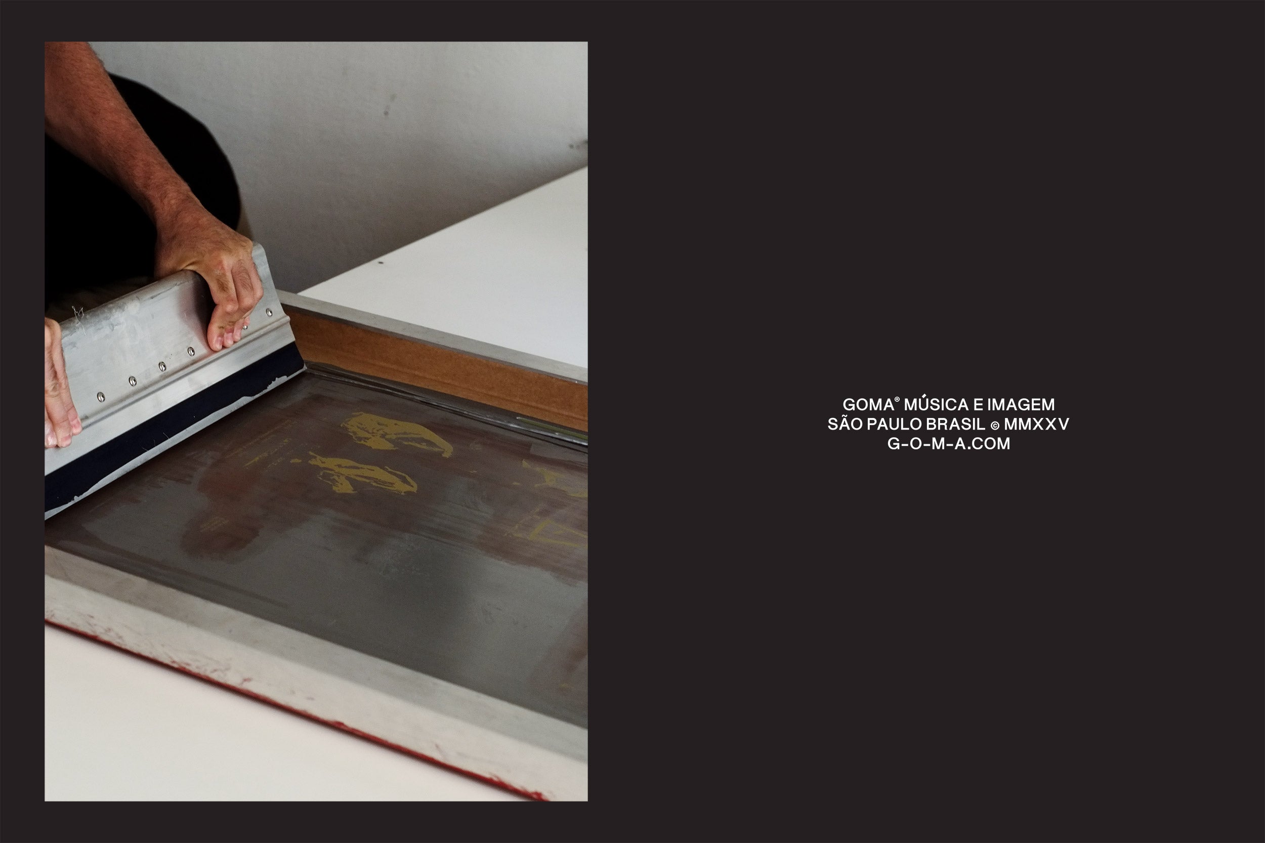 Uma pessoa pratica habilmente serigrafia sobre uma superfície plana emoldurada por um retângulo. Ao fundo, o texto GOMA* MÚSICA E IMAGEM SÃO PAULO BRASIL MMXXV G-O-M-A.COM aparece contra uma seção escura, sugerindo uma coleção de edição limitada de Autumn came, with wind and gold da GOMA®.