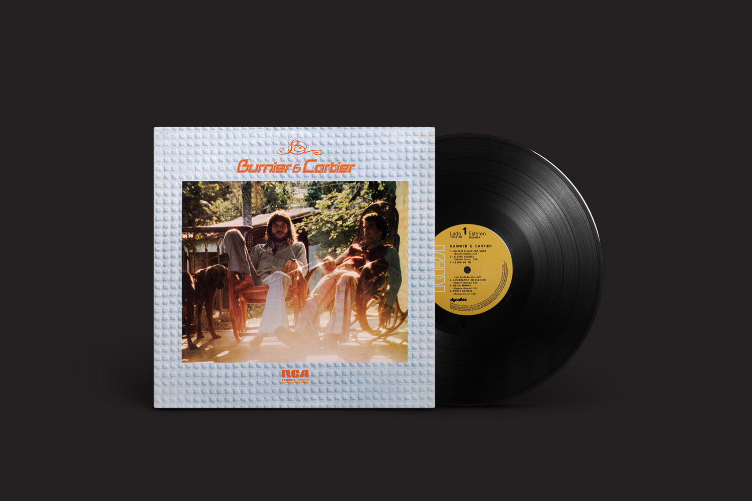 Um disco de vinil intitulado "Burnier & Cartier: 1974", de Mr. Bongo, é visto parcialmente fora de sua capa, que mostra duas pessoas em cadeiras de balanço cercadas por vegetação, com o título do álbum impresso acima da foto.