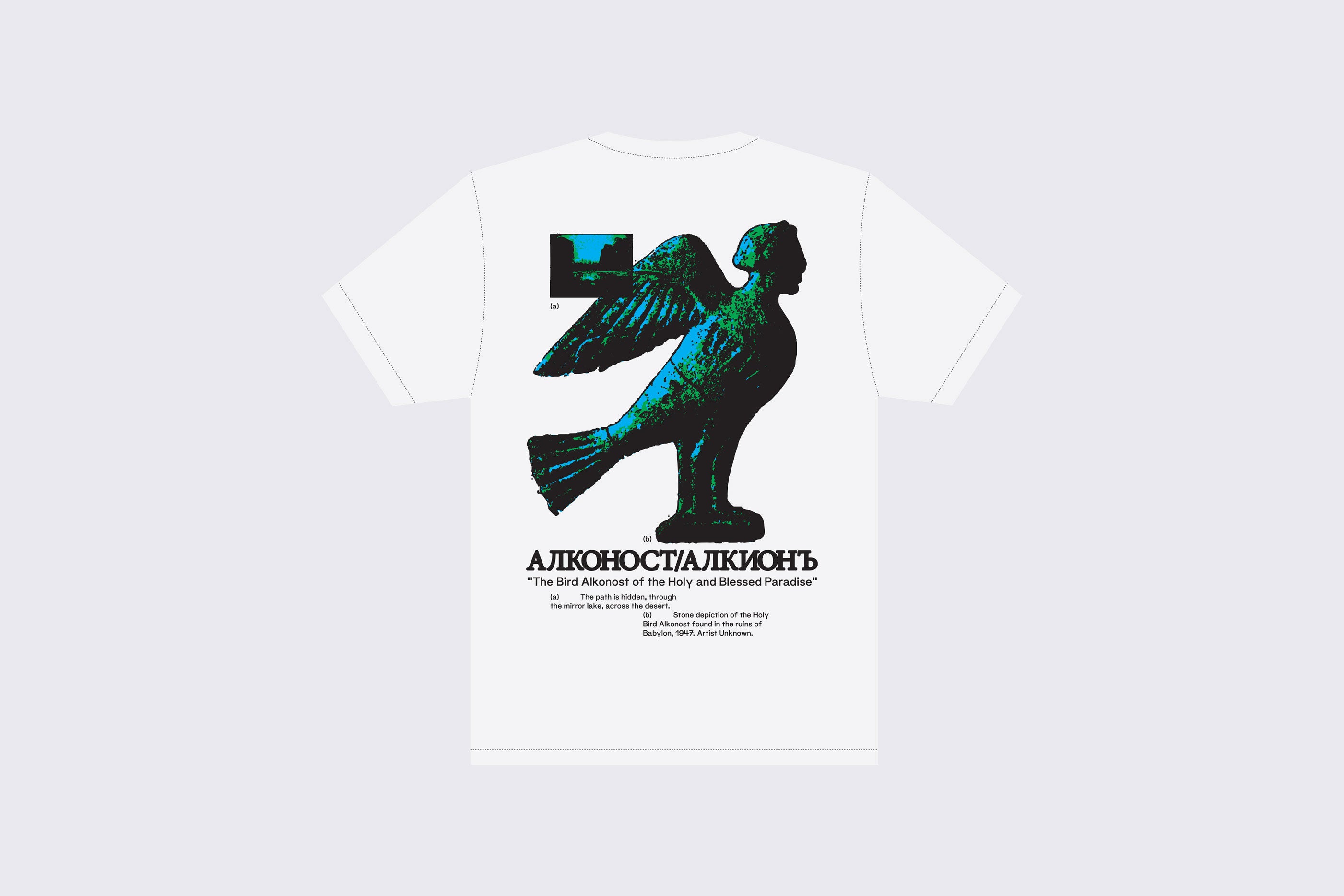 A camiseta de grandes dimensões GOMA® "The Bird Alkonost of the Holy and Blessed Paradise" (O pássaro Alkonost do Paraíso Sagrado e Abençoado) é feita de 100% algodão e apresenta uma escultura arrojada de um pássaro azul-esverdeado na parte de trás com texto em cirílico e sua tradução em inglês abaixo.
