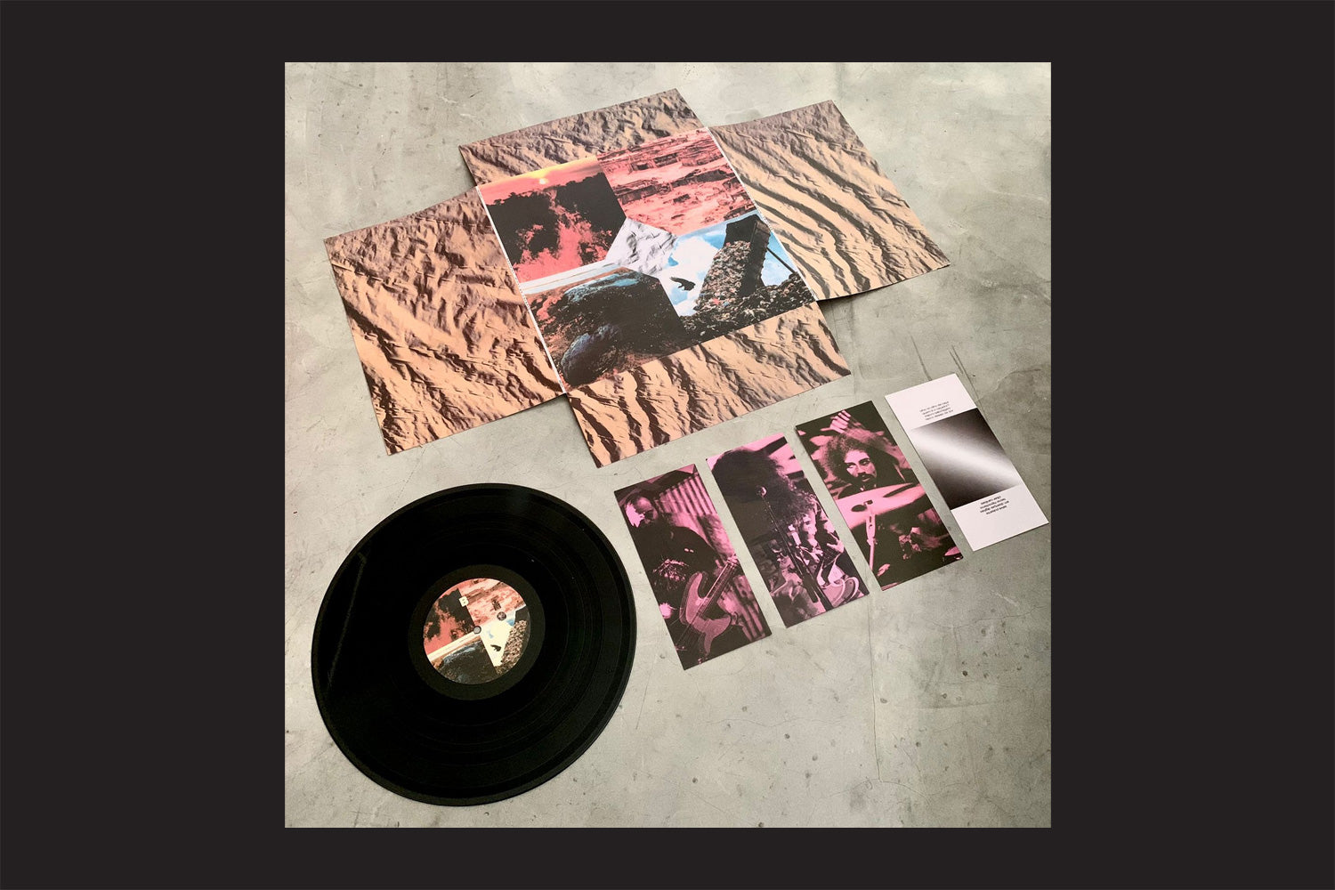 Deaf Kids: Ritos Do Colapso, da Nada Nada Discos, é mostrado com sua capa abstrata, capa desdobrada com estampa de deserto e dois encartes cor-de-rosa, tudo sobre uma superfície cinza lisa - refletindo o espírito punk transcendental brasileiro da banda.