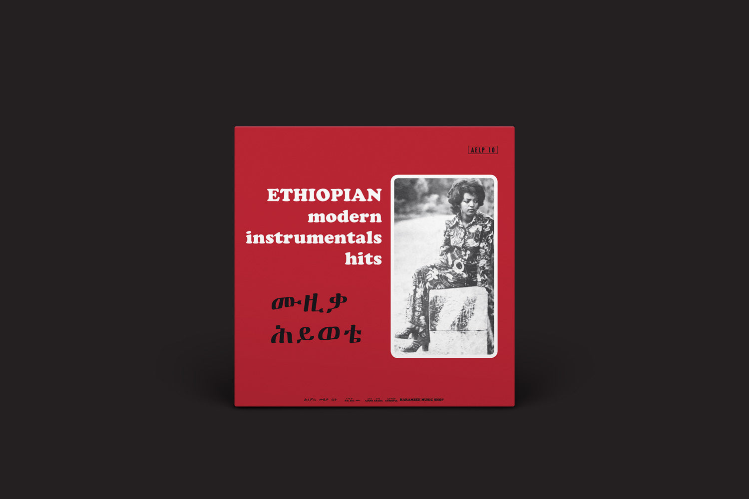 A capa vermelha de "Ethiopian Modern Instrumentals Hits = ሙዚቃ ሕይወቴ: v/a", do Heavenly Sweetness, mostra um retrato ao ar livre em preto e branco com escrita amárica, destacando artistas como Mulatu Astatké e Tèsfa-Maryam Kidané.