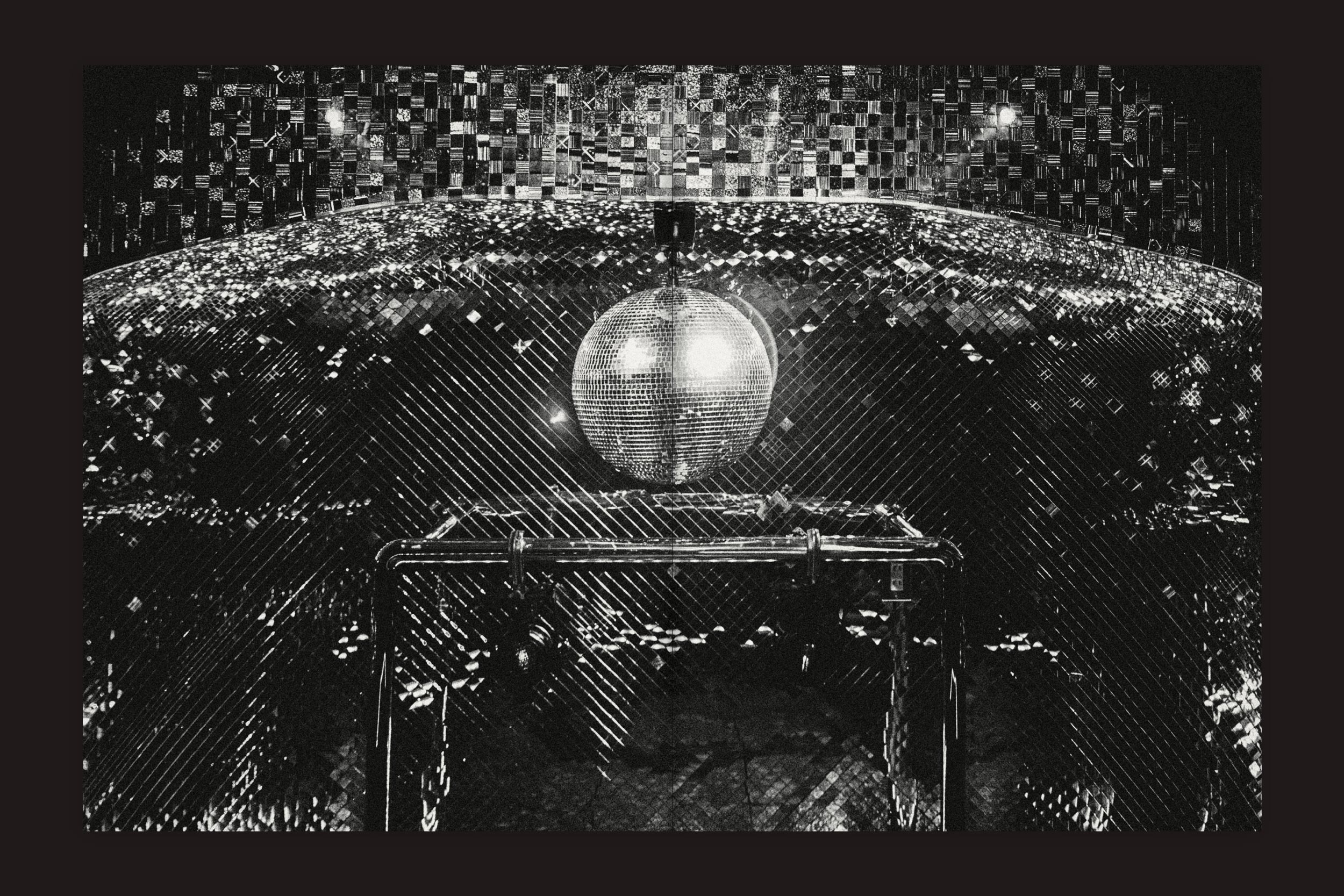 Uma foto em preto e branco de uma bola de discoteca brilhante ilumina um barco subterrâneo escuro, capturando a energia vibrante de Shinsaibashi em "Lucas Gibson: Shinsaibashi 2-18-9", de Selo Turvo.