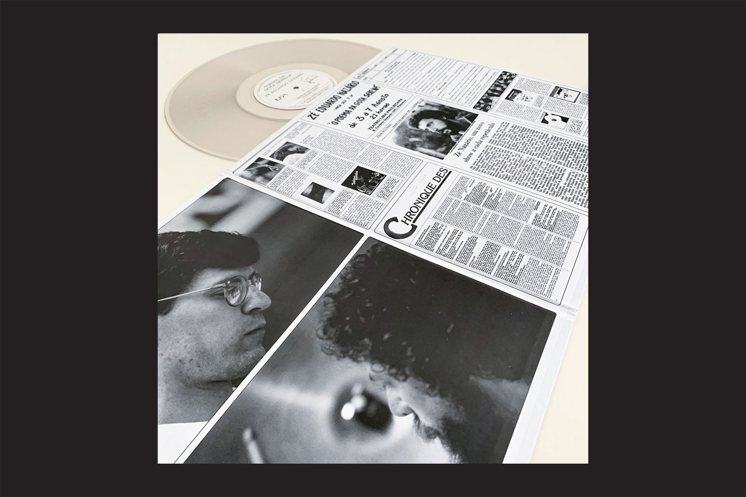 Um vinil translúcido aparece acima da capa em preto e branco, estilo jornal, de "Zé Eduardo Nazario: Poema da Gota Serena", da Nada Nada Discos, com artigos, manchetes e fotos de perfil - evocando o espírito do free jazz.